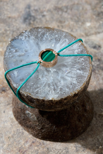 Bracelet cordon vert en malachite posé sur un support - Joaillerie Paris